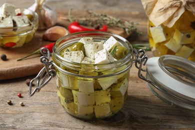 Photo of Composition with pickled feta cheese in jar on wooden table