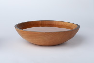 Photo of Wooden bowl full of water on white background