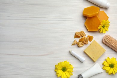 Photo of Flat lay composition with beeswax and cosmetic products on white wooden table. Space for text