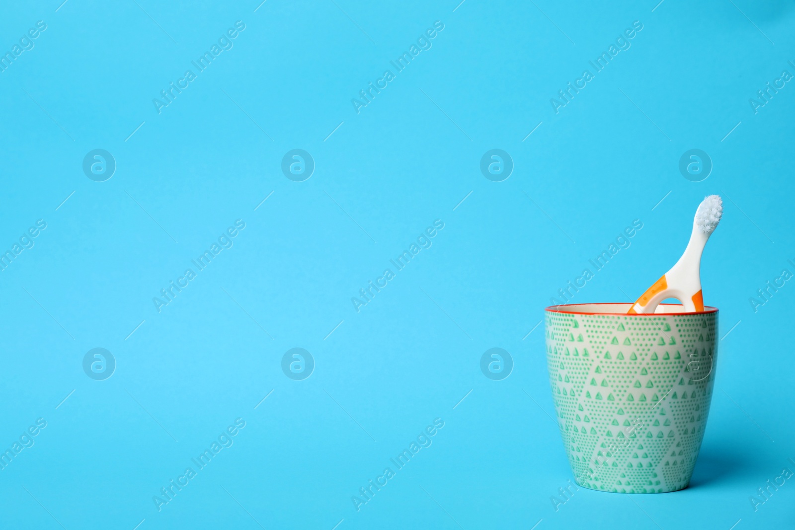 Photo of Baby toothbrush in holder and space for text on color background