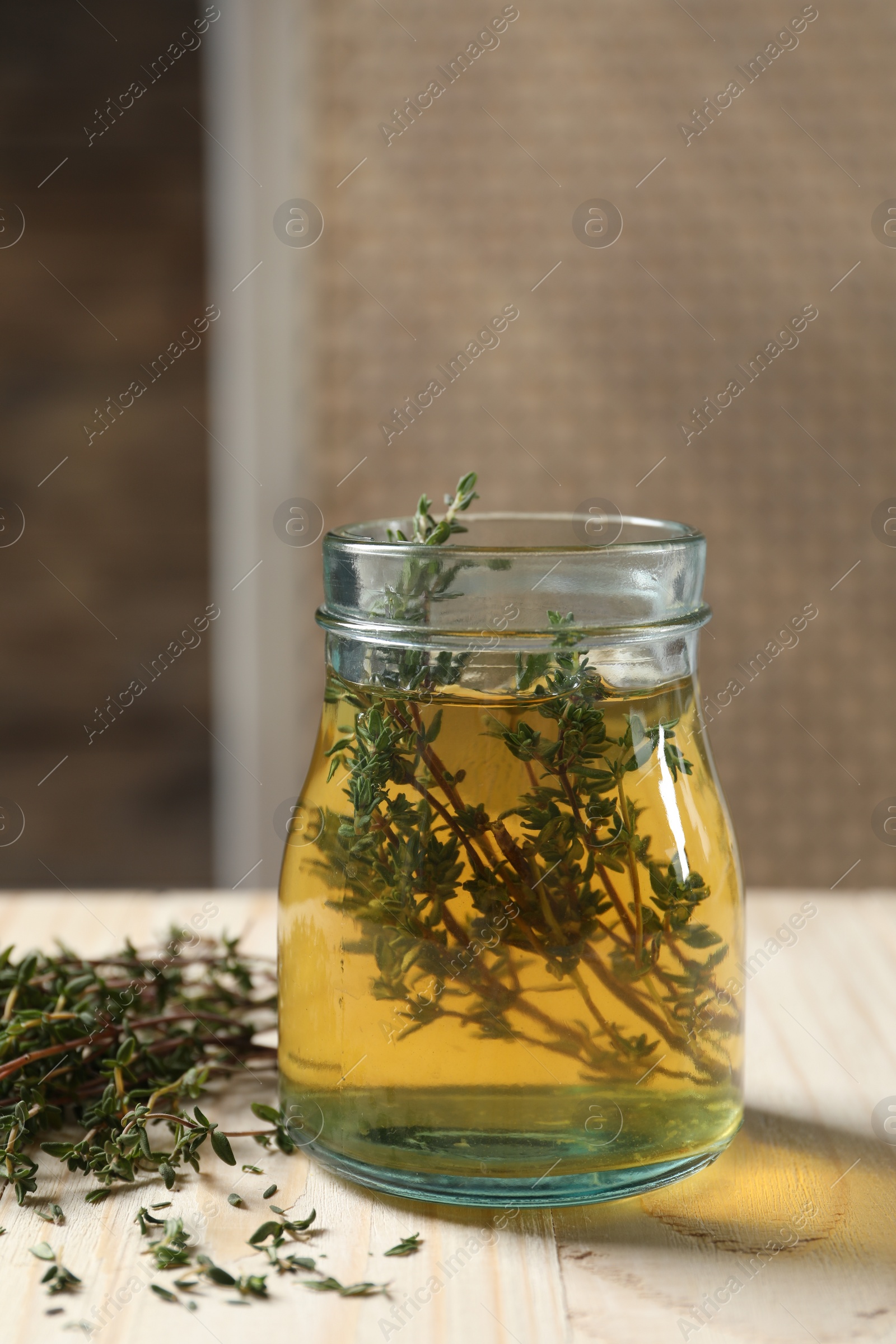 Photo of Aromatic herbal tea with thyme on white wooden table indoors