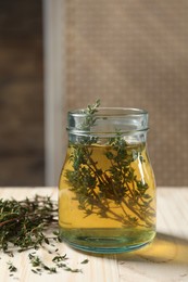 Aromatic herbal tea with thyme on white wooden table indoors