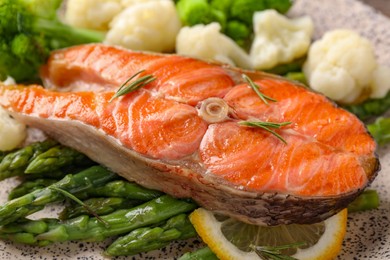 Photo of Healthy meal. Tasty grilled salmon with lemon and vegetables on plate, closeup