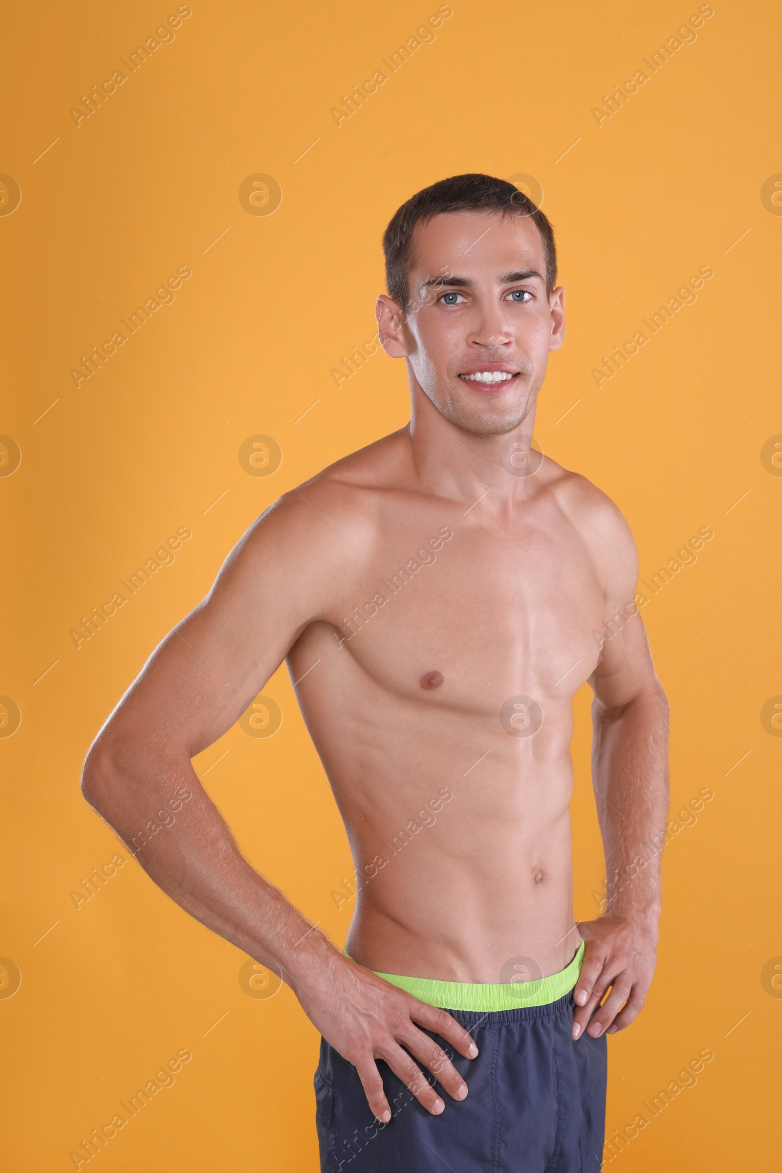 Photo of Handsome shirtless man with slim body on yellow background