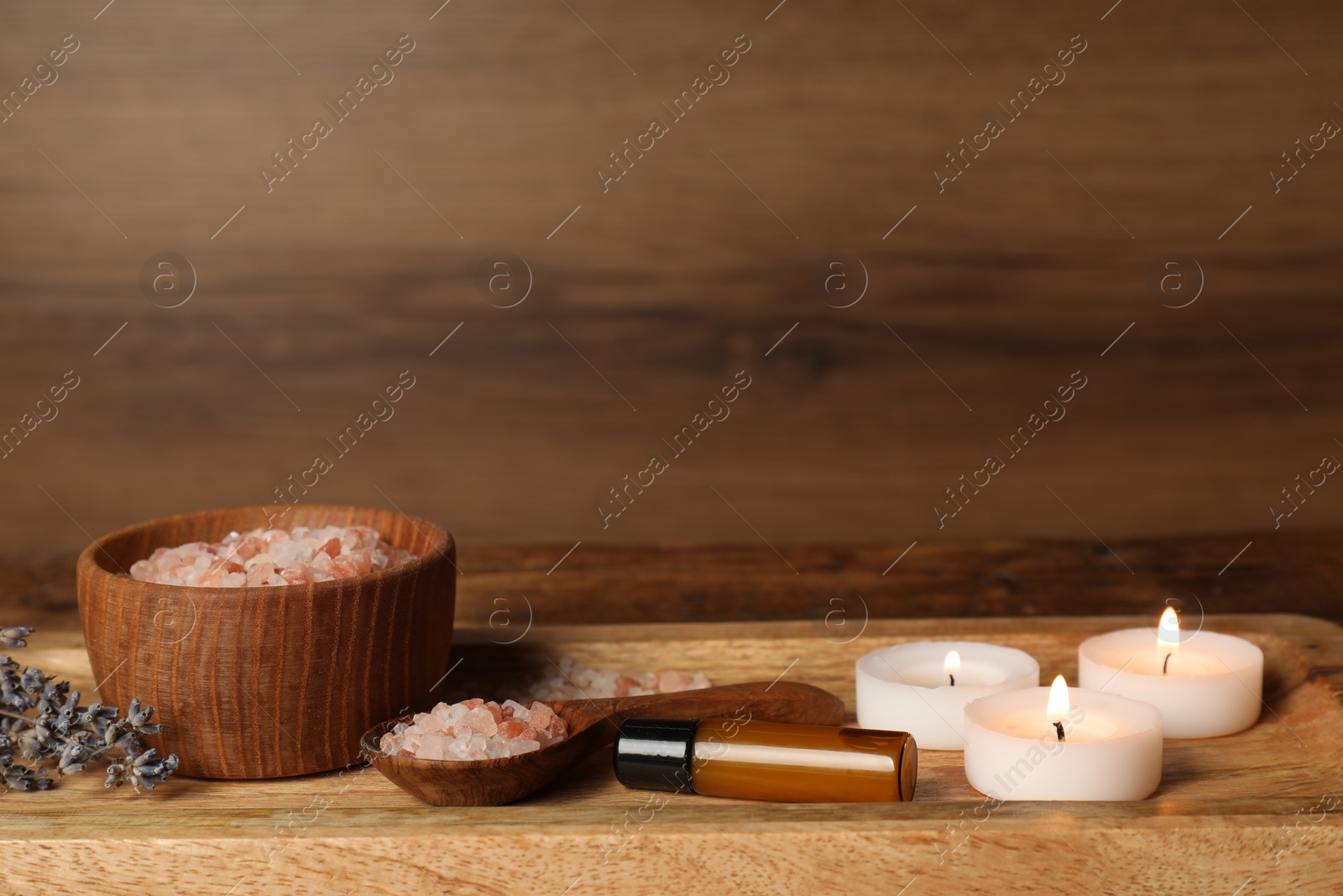 Photo of Different aromatherapy products and burning candles on wooden table