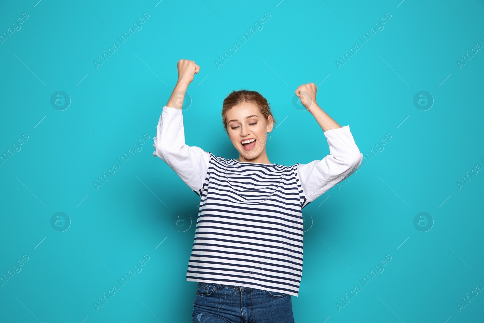 Photo of Happy young woman celebrating victory on color background