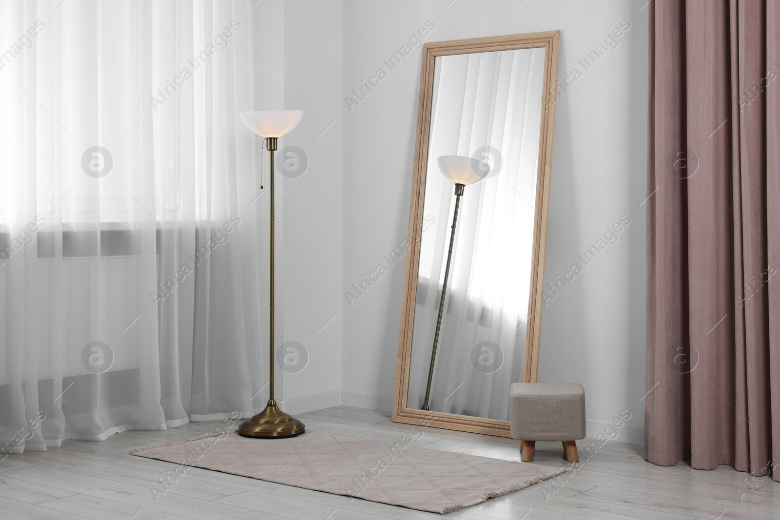 Photo of Stylish makeup room interior with long mirror and lamp