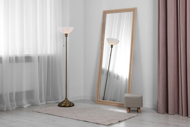 Photo of Stylish makeup room interior with long mirror and lamp