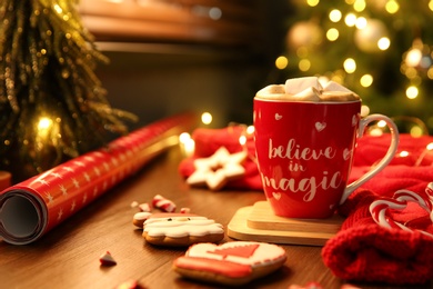 Photo of Tasty hot drink in cup with inscription Believe in Magic, space for text. Christmas atmosphere