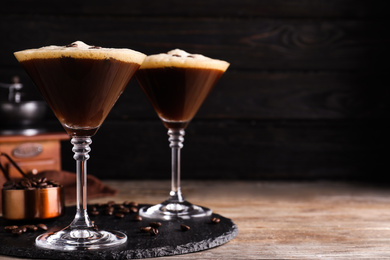 Photo of Glasses of fresh coffee cocktail on wooden table. Space for text