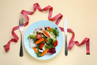 Photo of Measuring tape, vegetable salad and fork on beige background, flat lay. Weight loss concept
