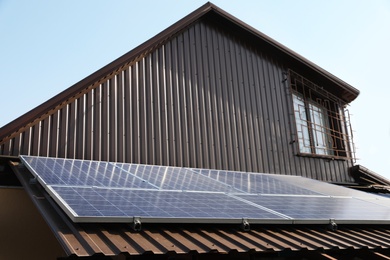 Photo of House with installed solar panels on roof. Alternative energy source