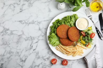 Photo of Delicious fried breaded cutlets with garnish served on white marble table, flat lay. Space for text