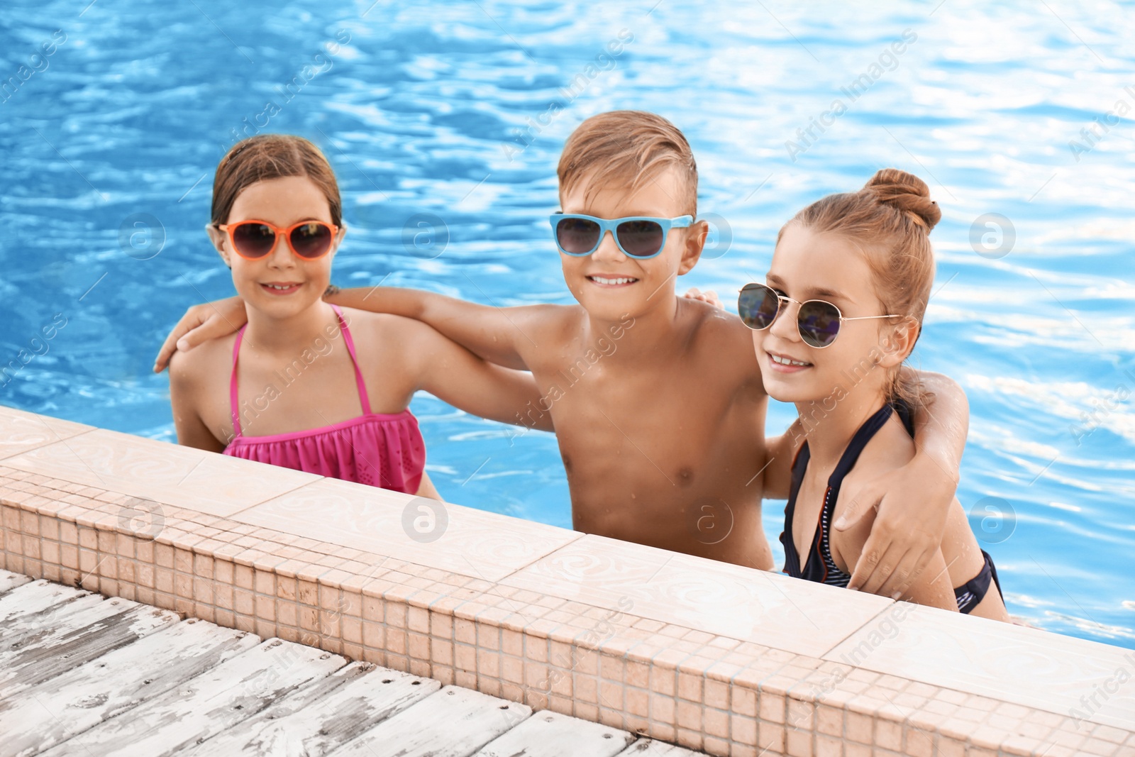 Photo of Happy children in swimming pool on sunny day