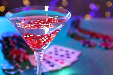 Photo of Cocktail with casino dice in glass on table, closeup. Space for text