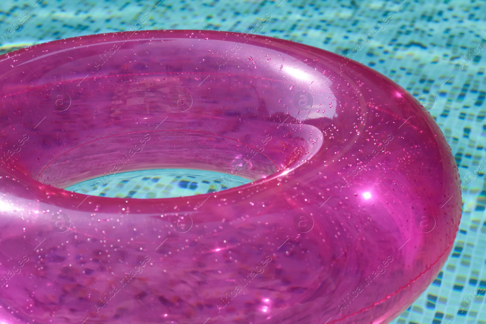 Photo of Inflatable ring floating on water in swimming pool, closeup