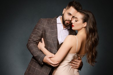 Photo of Handsome bearded man with sexy lady on grey background