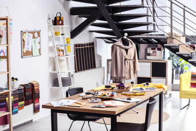 Photo of Fashion designer's workplace in studio. Creating new clothes