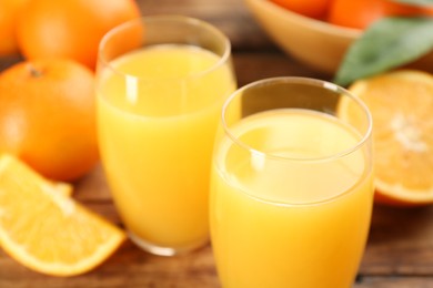 Photo of Delicious orange juice and fresh fruits on table, closeup