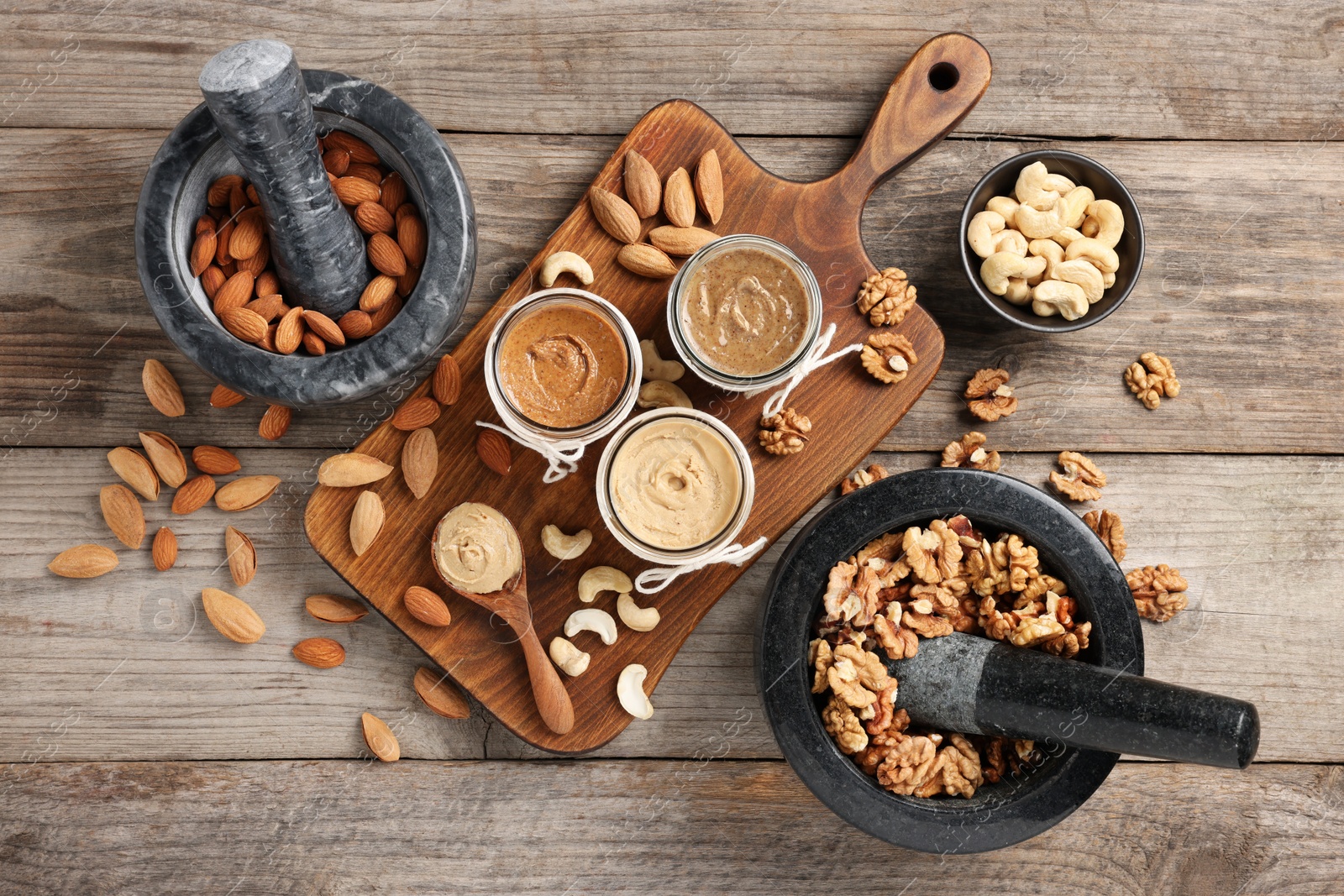 Photo of Making nut butters from different nuts. Fat lay composition on wooden table