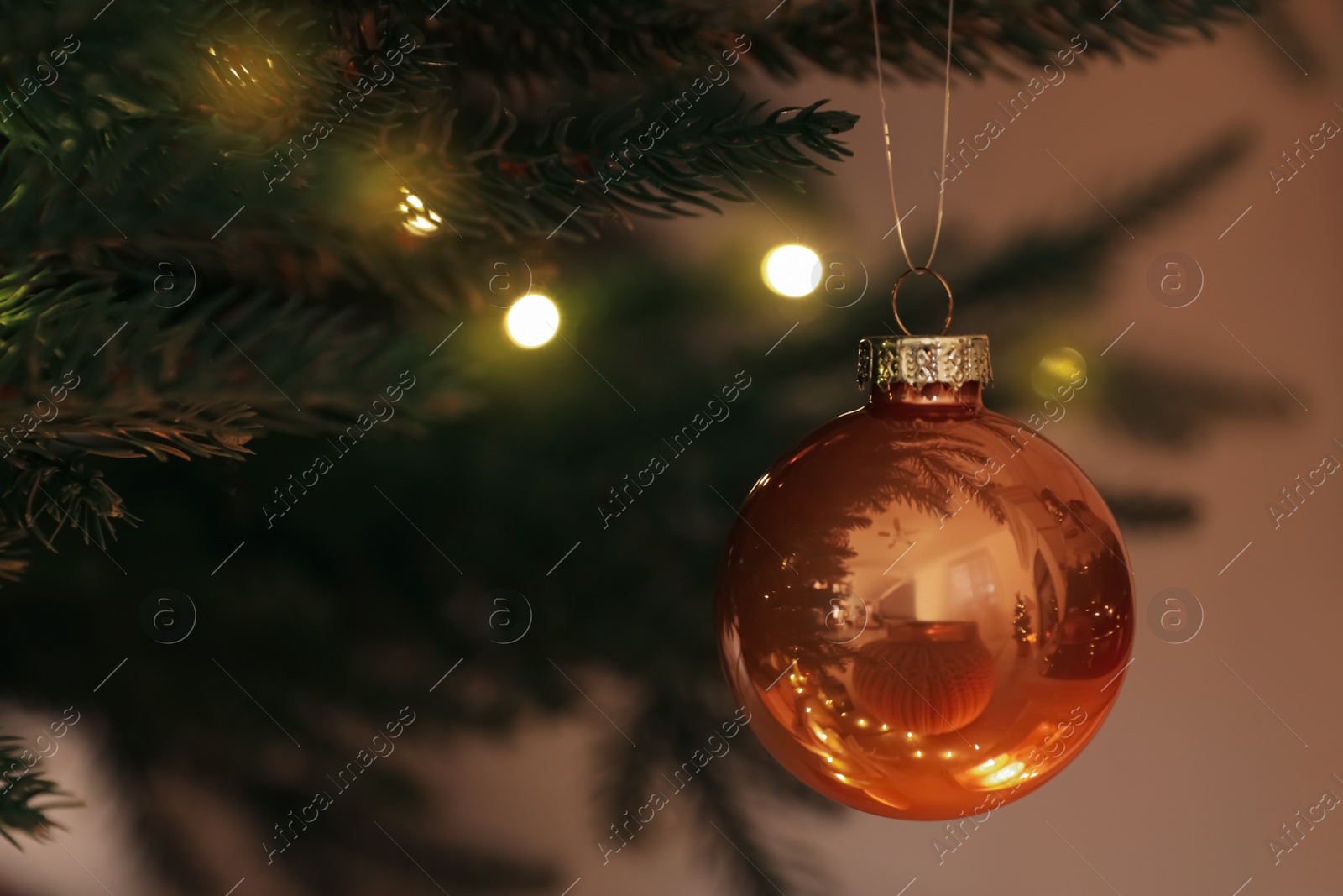 Photo of Beautiful bauble and fairy lights on Christmas tree, closeup