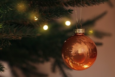 Photo of Beautiful bauble and fairy lights on Christmas tree, closeup
