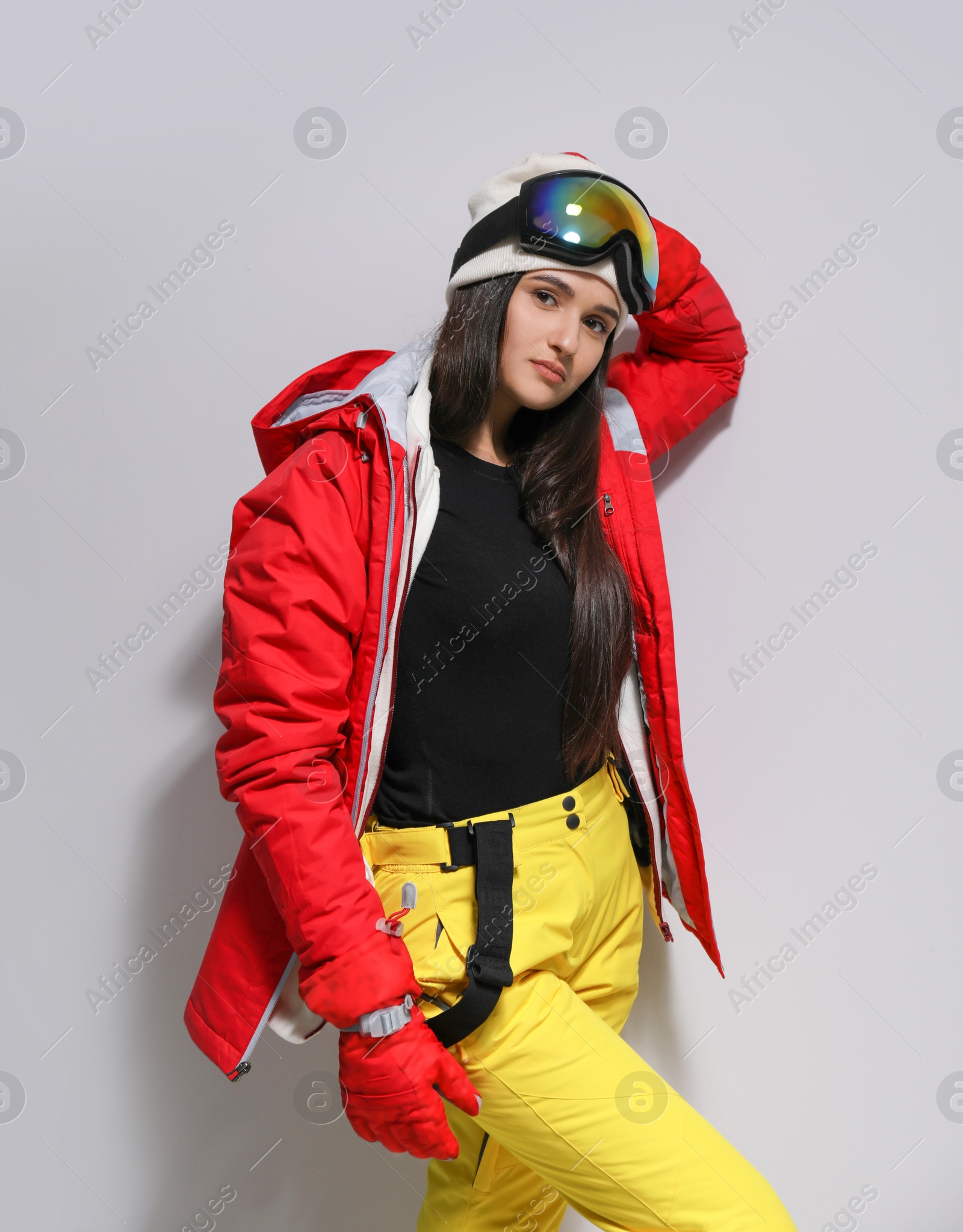 Photo of Woman wearing stylish winter sport clothes on light grey background