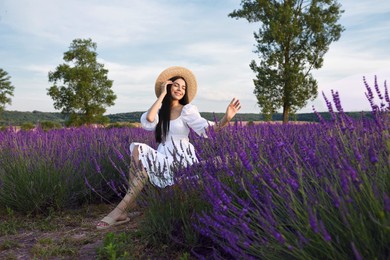 Photo of Beautiful young woman sitting in lavender field