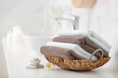 Photo of Basket with clean towels on counter in bathroom