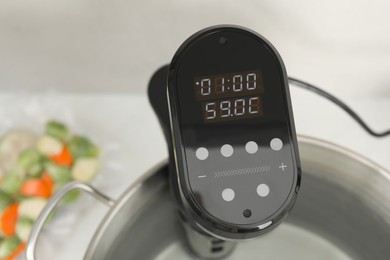 Sous vide cooker in pot on table, closeup. Thermal immersion circulator