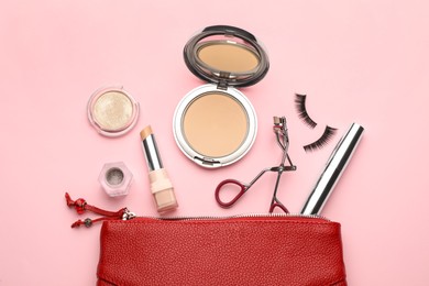 Photo of Eyelash curler, cosmetic bag and makeup products on pink background, flat lay