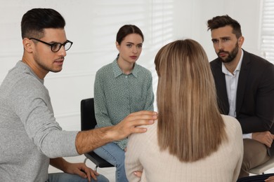 Photo of Psychotherapist working with patients at group session indoors