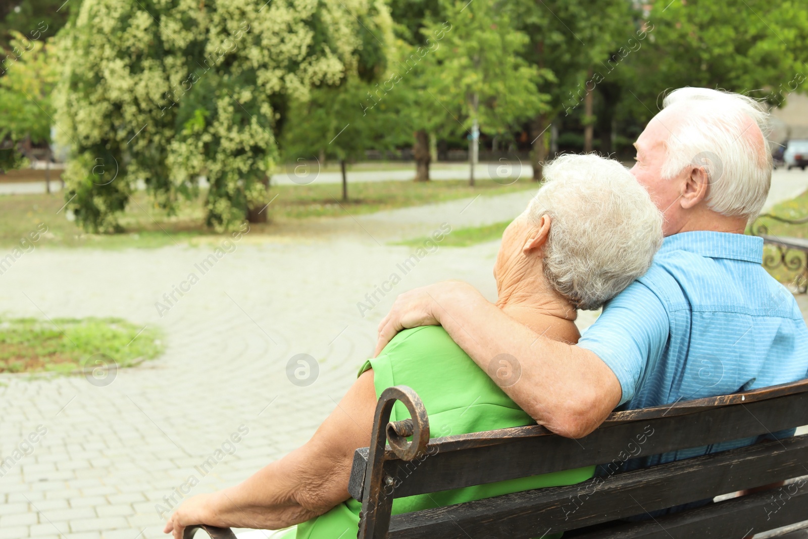 Photo of Elderly couple resting on bench in park