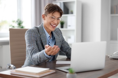 Man using video chat during webinar at wooden table in office