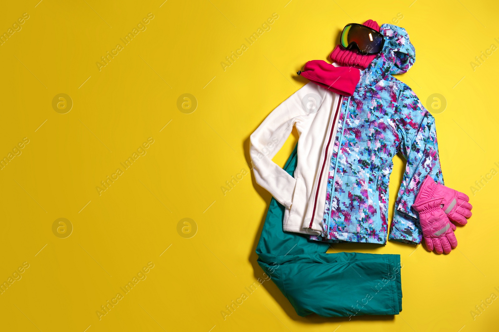 Photo of Stylish winter sport clothes on yellow background, flat lay. Space for text