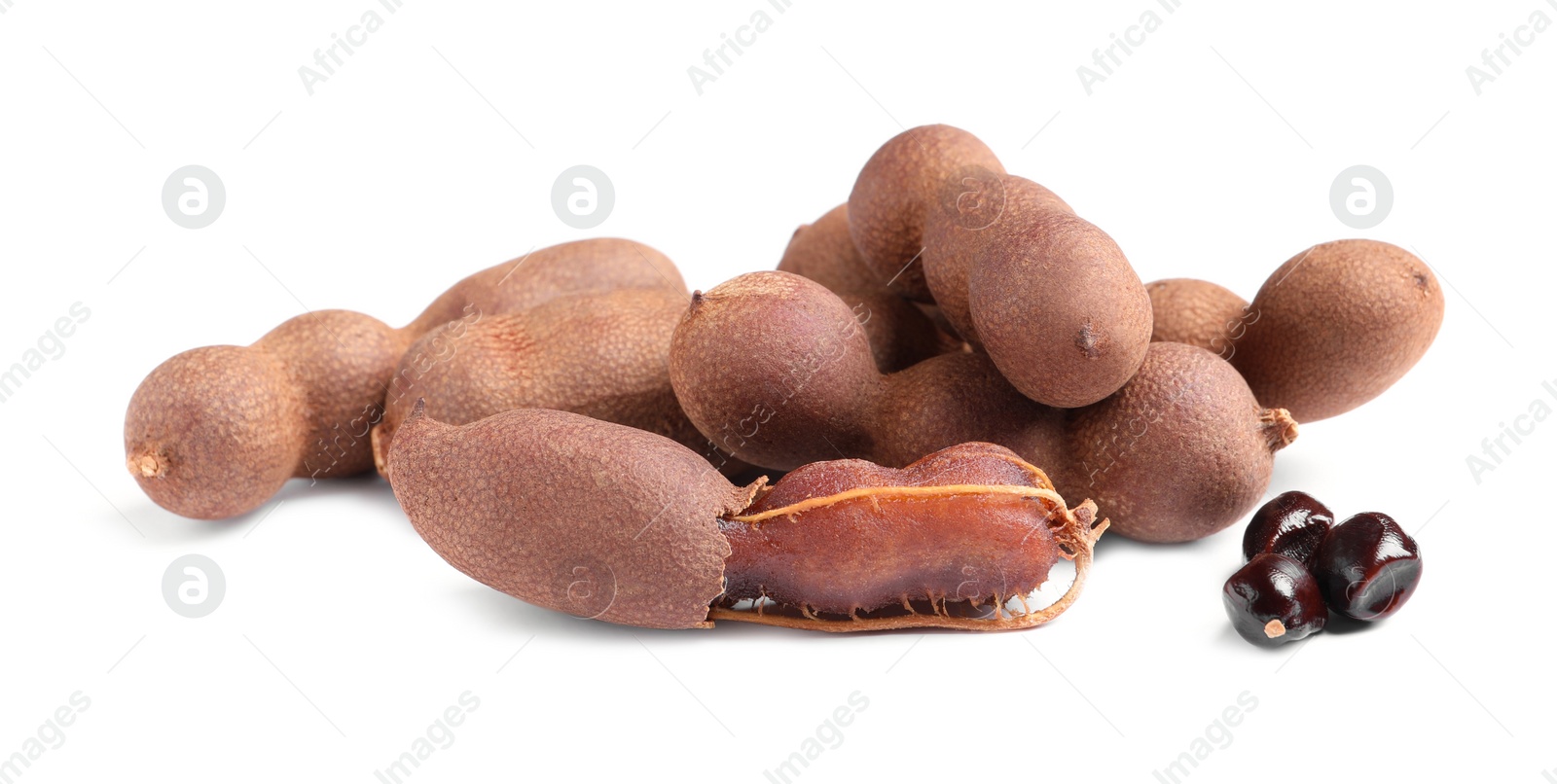 Photo of Delicious ripe tamarinds and seeds on white background. Exotic fruit