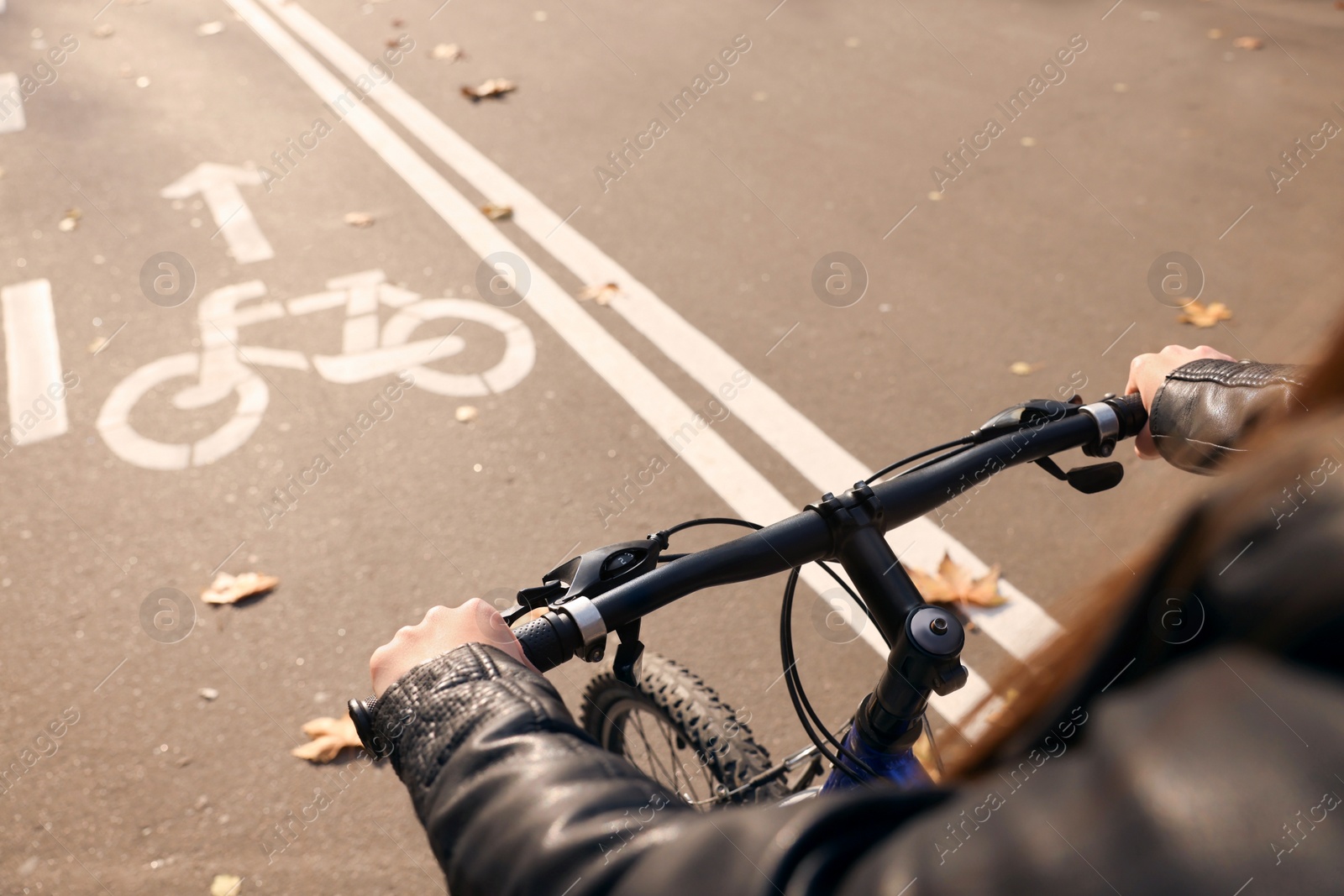 Photo of Woman riding bicycle on lane in city, closeup