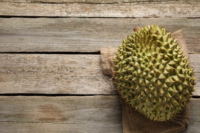 Photo of Ripe durian on wooden table, top view. Space for text