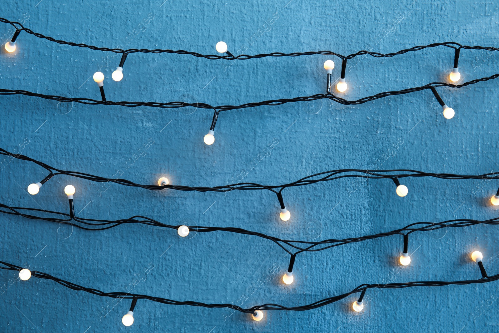 Photo of Beautiful bright Christmas lights on color background