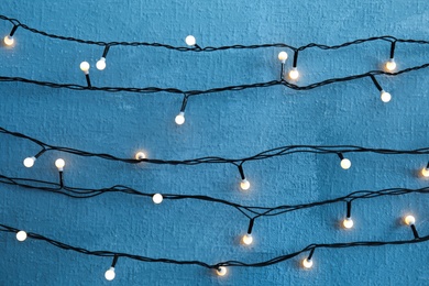 Beautiful bright Christmas lights on color background