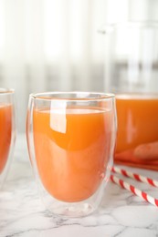 Photo of Freshly made carrot juice on white marble table