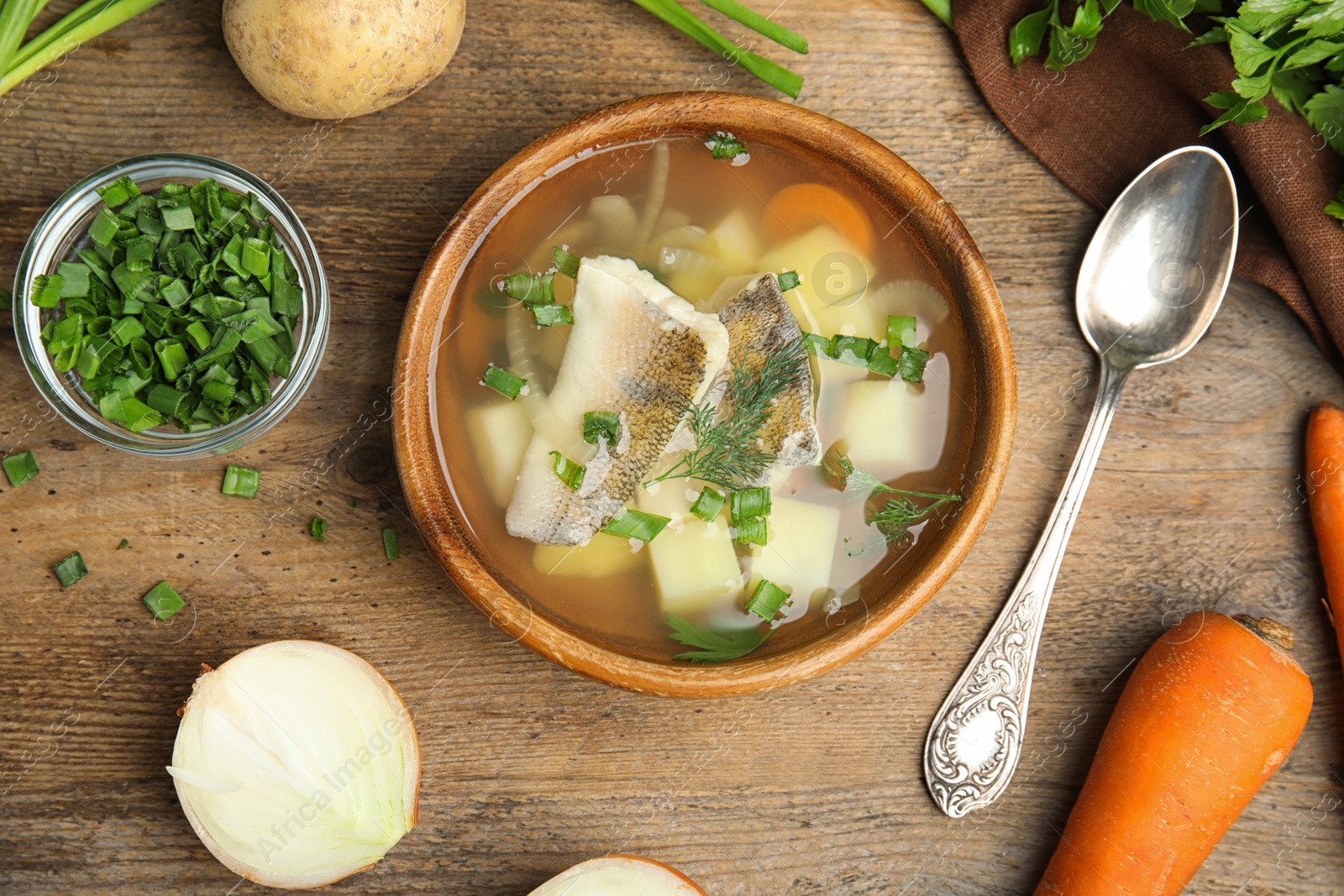 Photo of Delicious fish soup served on wooden table, flat lay