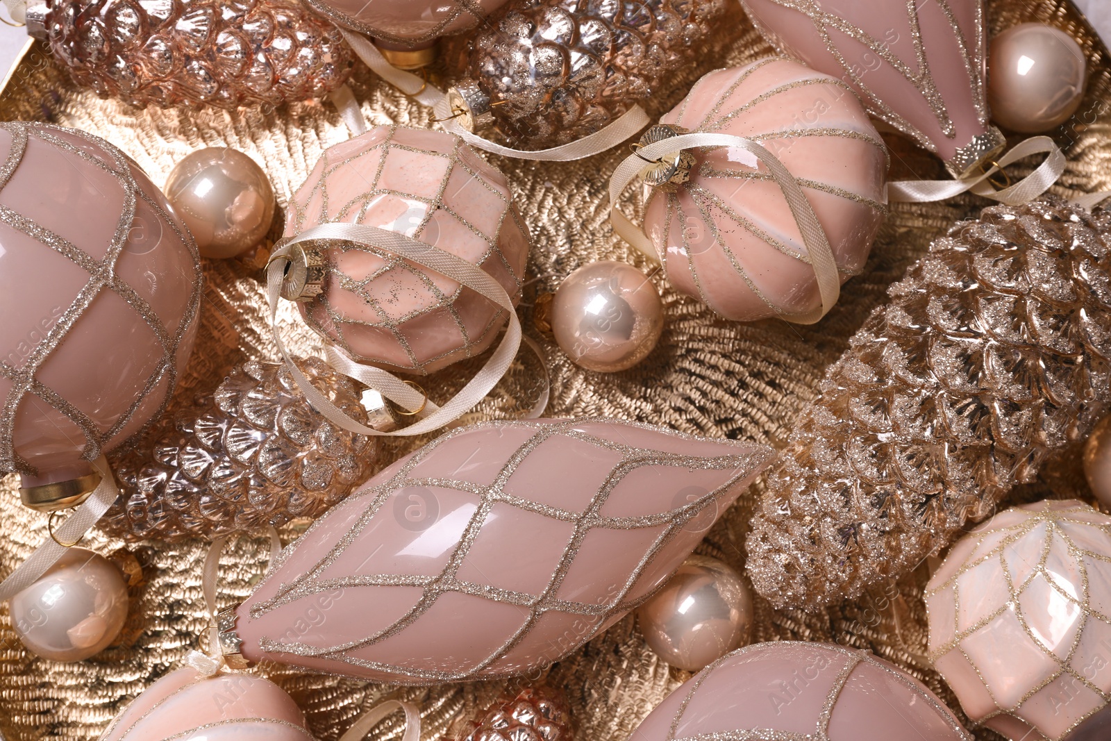 Photo of Christmas baubles on golden plate, top view