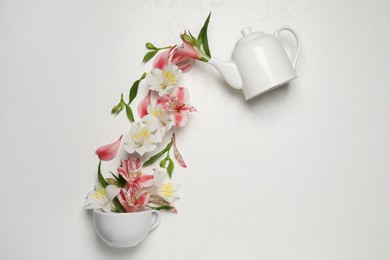 Photo of Composition with beautiful flowers, cup and teapot on light background, top view