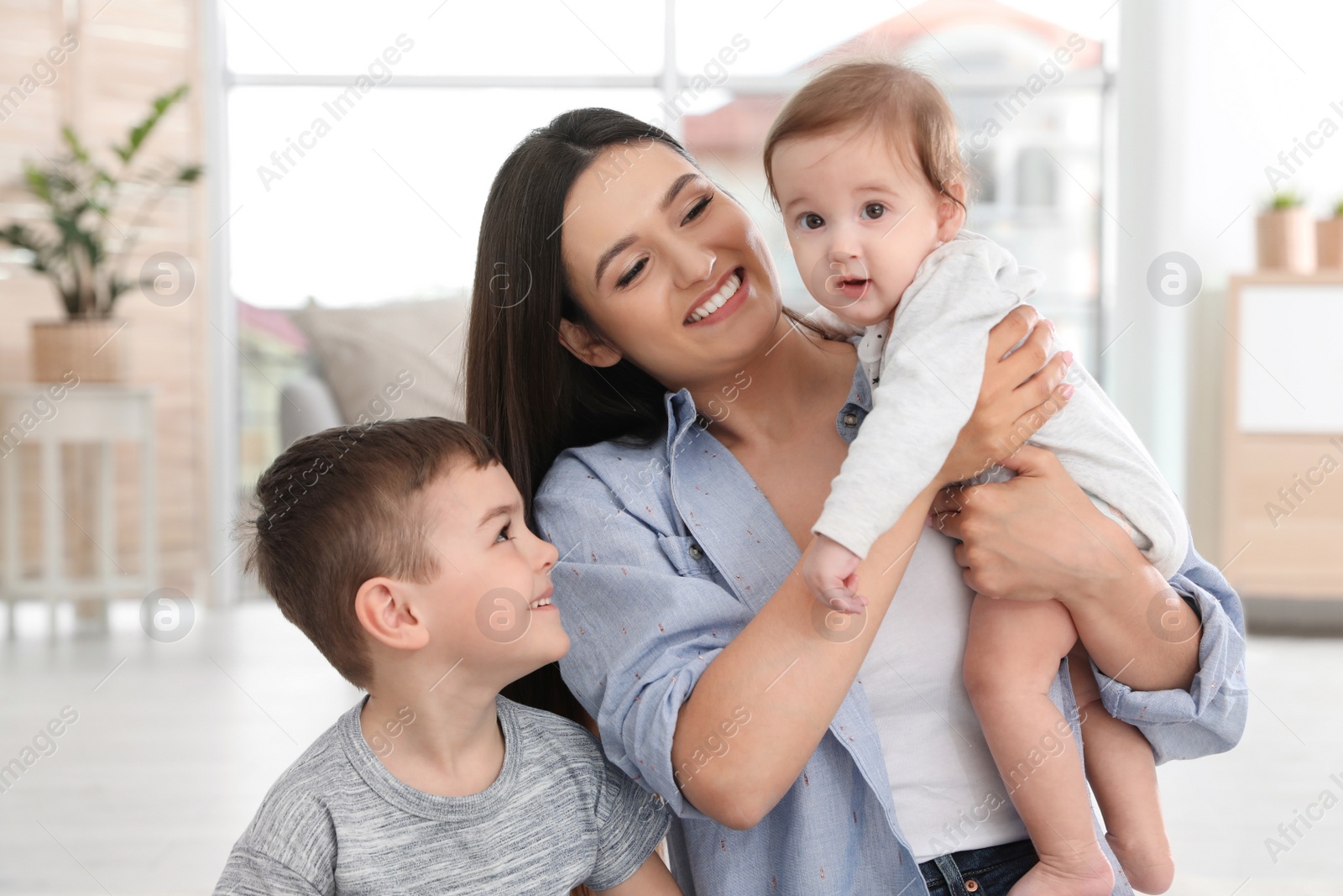 Photo of Happy mother with her cute children at home. Family time