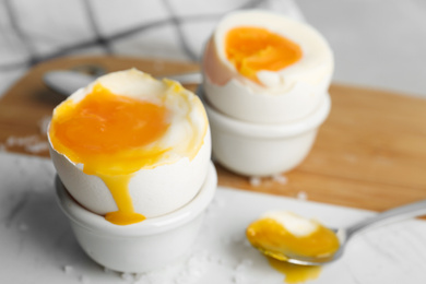 Photo of Soft boiled chicken eggs on white table, closeup