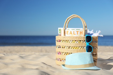 Stylish beach accessories for summer vacation on sand near sea. Space for text
