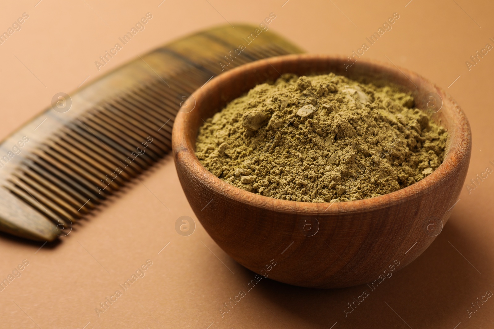 Photo of Henna powder and comb on beige background, closeup. Natural hair coloring