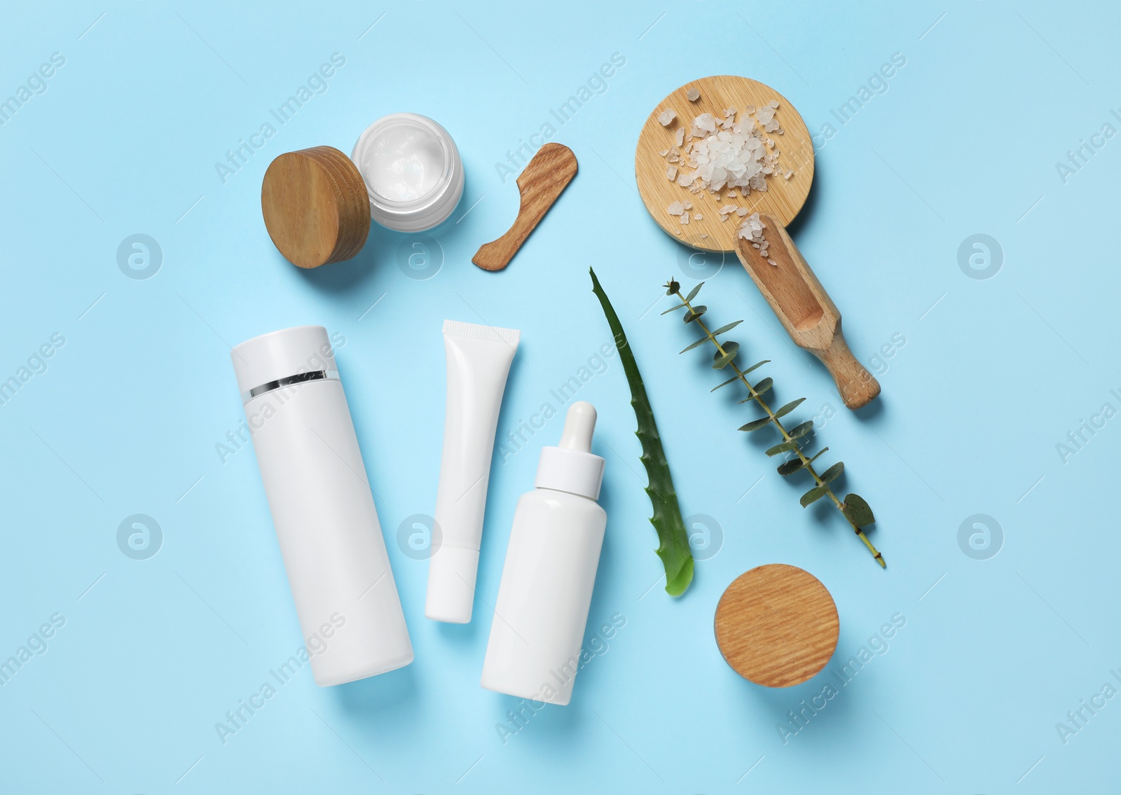 Photo of Different skin care products and natural ingredients on light blue background, flat lay