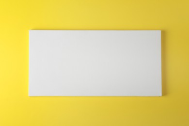 Photo of Blank canvas on yellow background, space for text